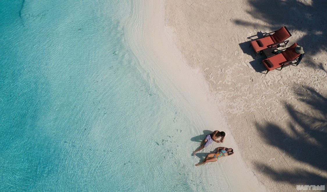 couple en lune de miel sur la plage de leur hotel à Bora Bora